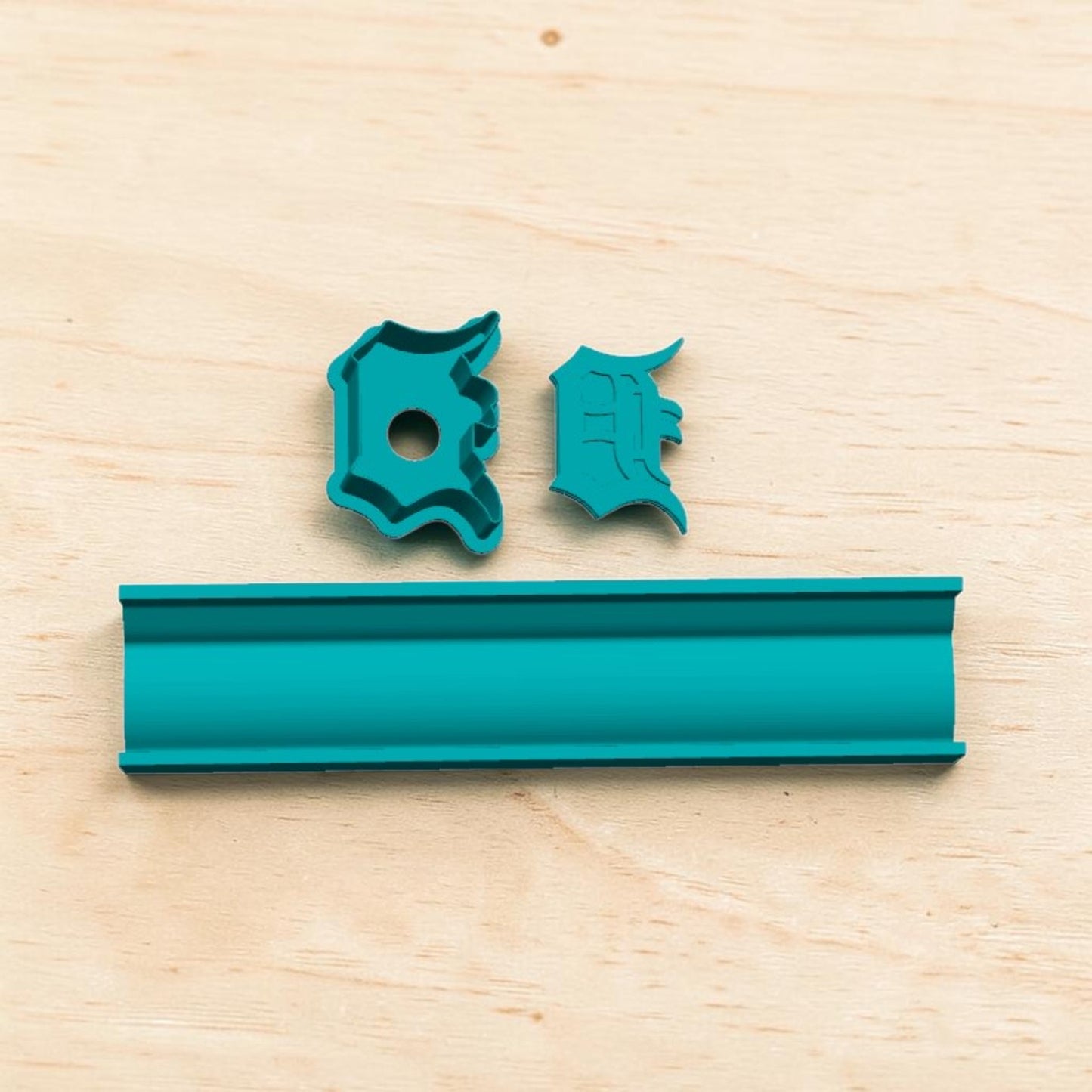 Detroit Tigers D cake pop mold and tray set — teal 3D‑printed baking tool with letter D and E cutters displayed on light wood surface.