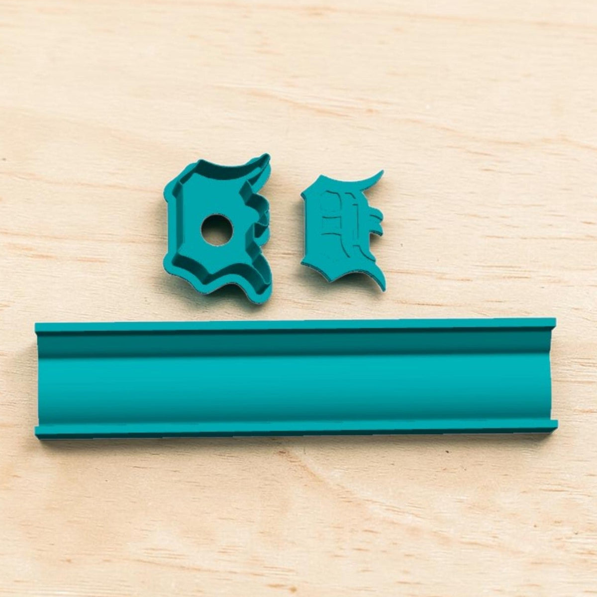 Detroit Tigers D cake pop mold and tray set — teal 3D‑printed baking tool with letter D and E cutters displayed on light wood surface.