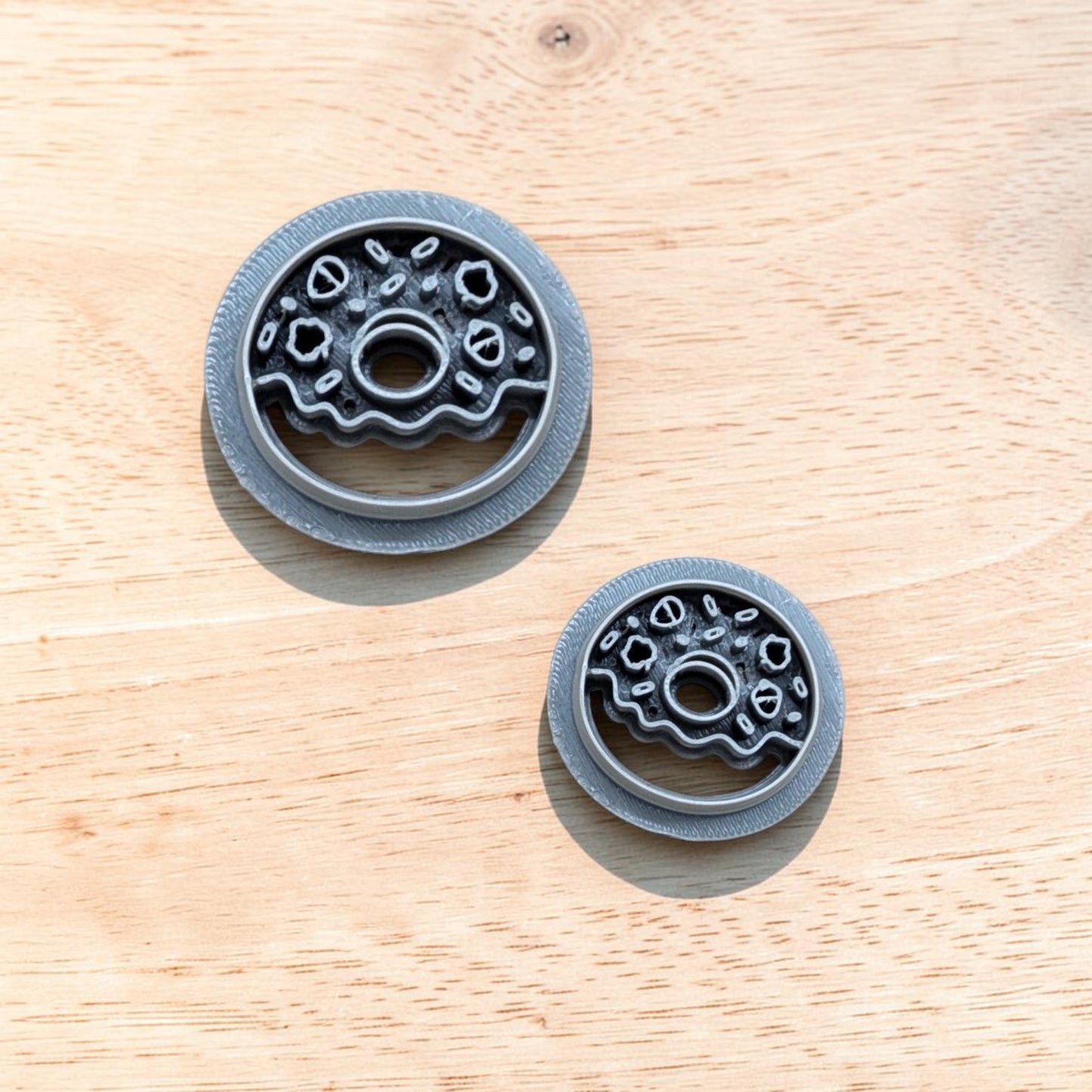 Two fall donut cookie cutters in different sizes with detailed icing and sprinkle designs, displayed on a light wooden surface—ideal for cookies, fondant, polymer clay, and pottery crafts.