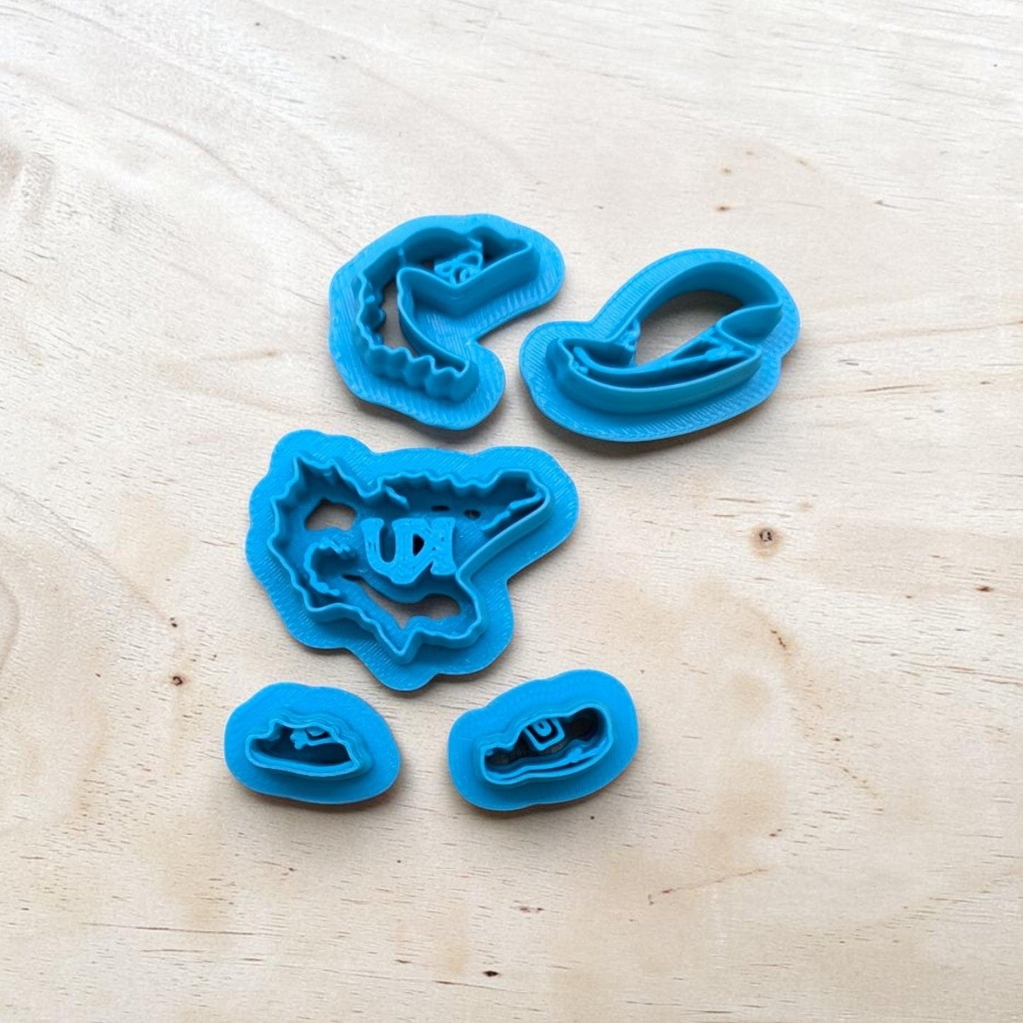 Layered set of blue cookie cutters on a wooden surface