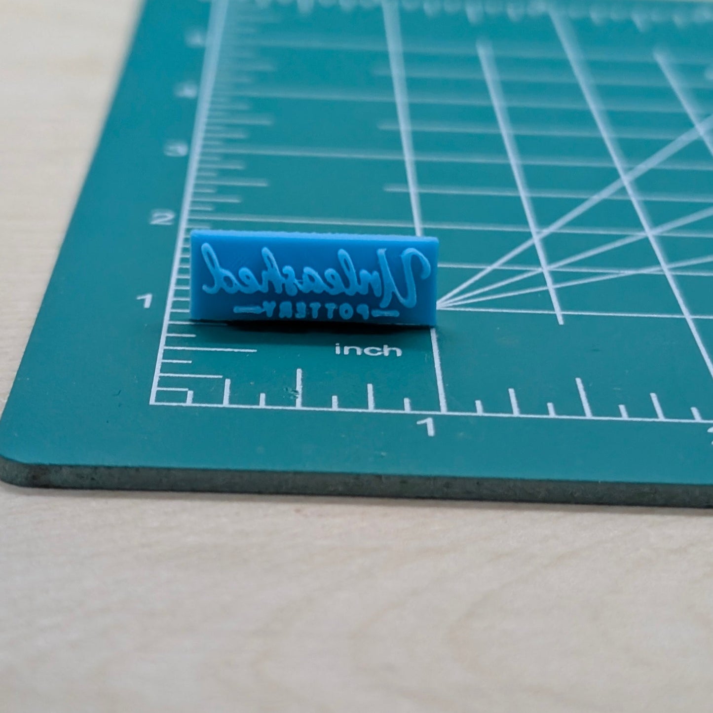 Blue stamp on a cutting mat with measurement lines