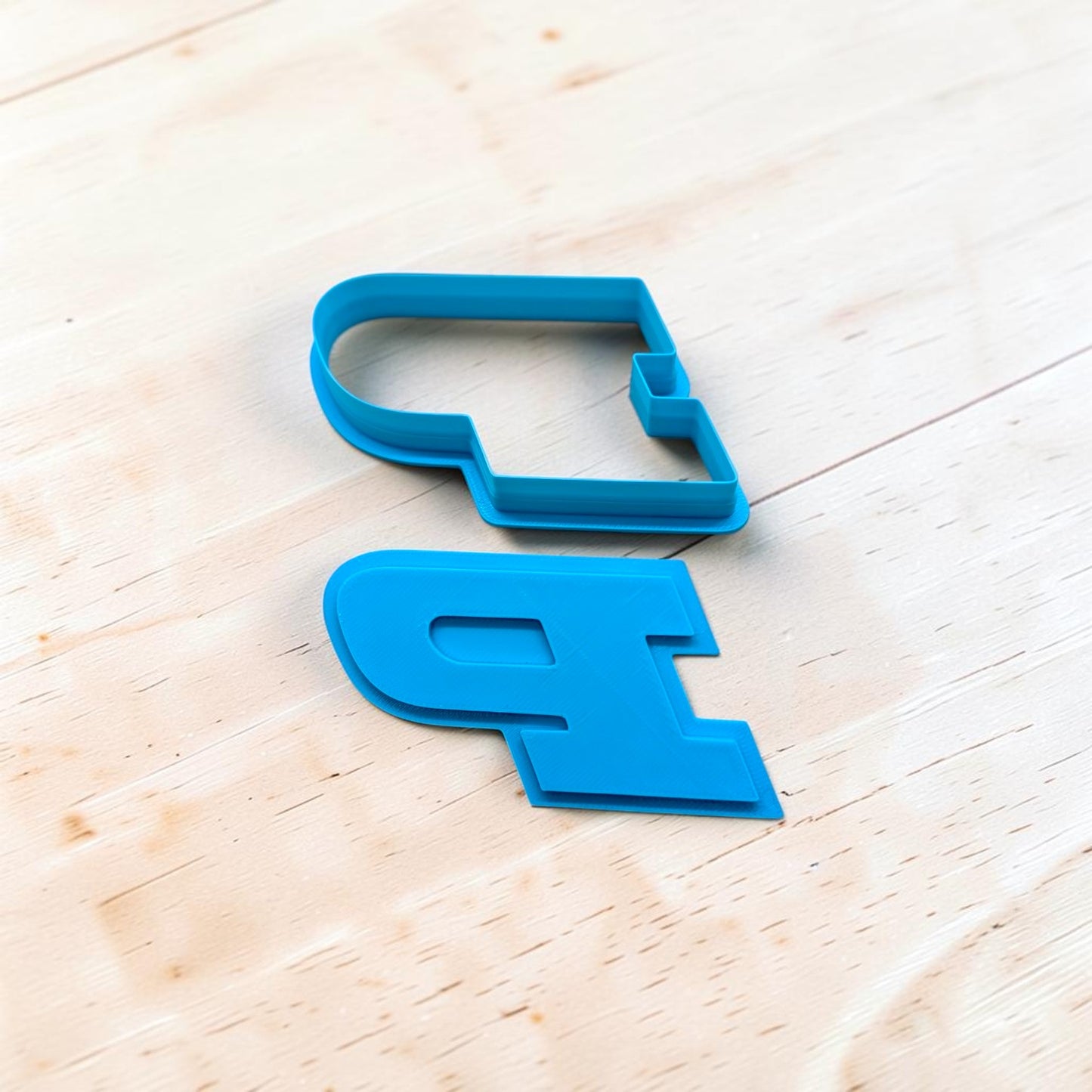 “blue Purdue P inspired cookie cutter and stamp set for cookies fondant and clay crafts on light wood background