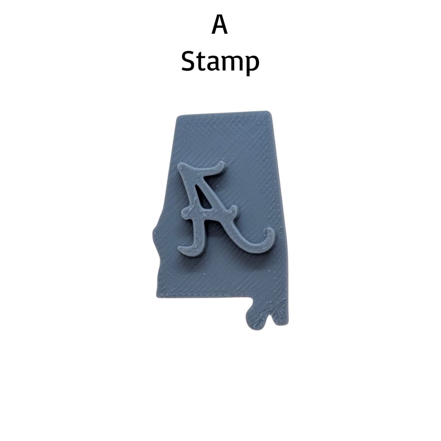 A gray 3D-printed Alabama state-shaped stamp featuring the Crimson Tide 'A' logo, shown on a plain white background with the text 'A Stamp' above it.