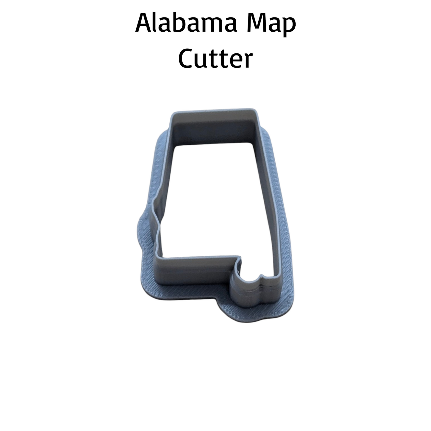 A gray plastic cookie cutter shaped like the state of Alabama, shown on a plain white background with the text 'Alabama Map Cutter' above it.