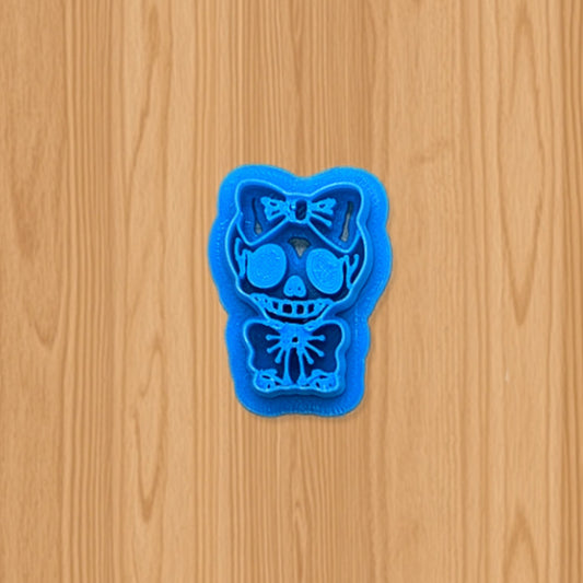 Blue skull-shaped cookie cutter on a wooden surface