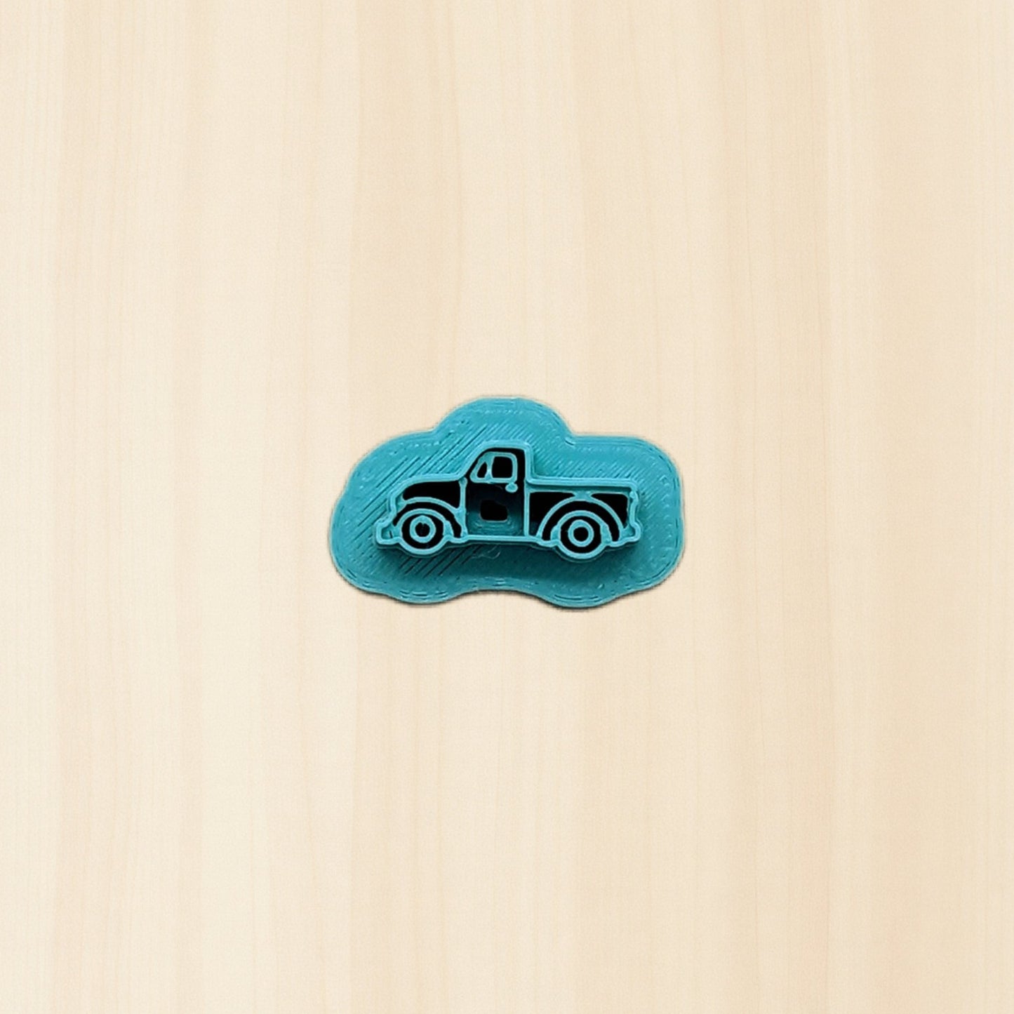 Blue truck-shaped cookie cutter object on a wood background