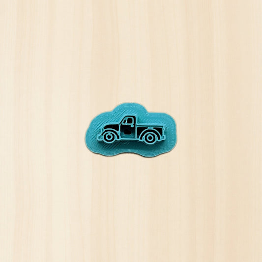 Blue truck-shaped cookie cutter object on a wood background