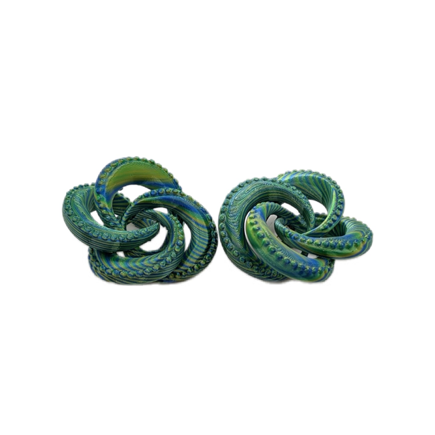 Pair of green and blue knot-shaped earrings on a white background