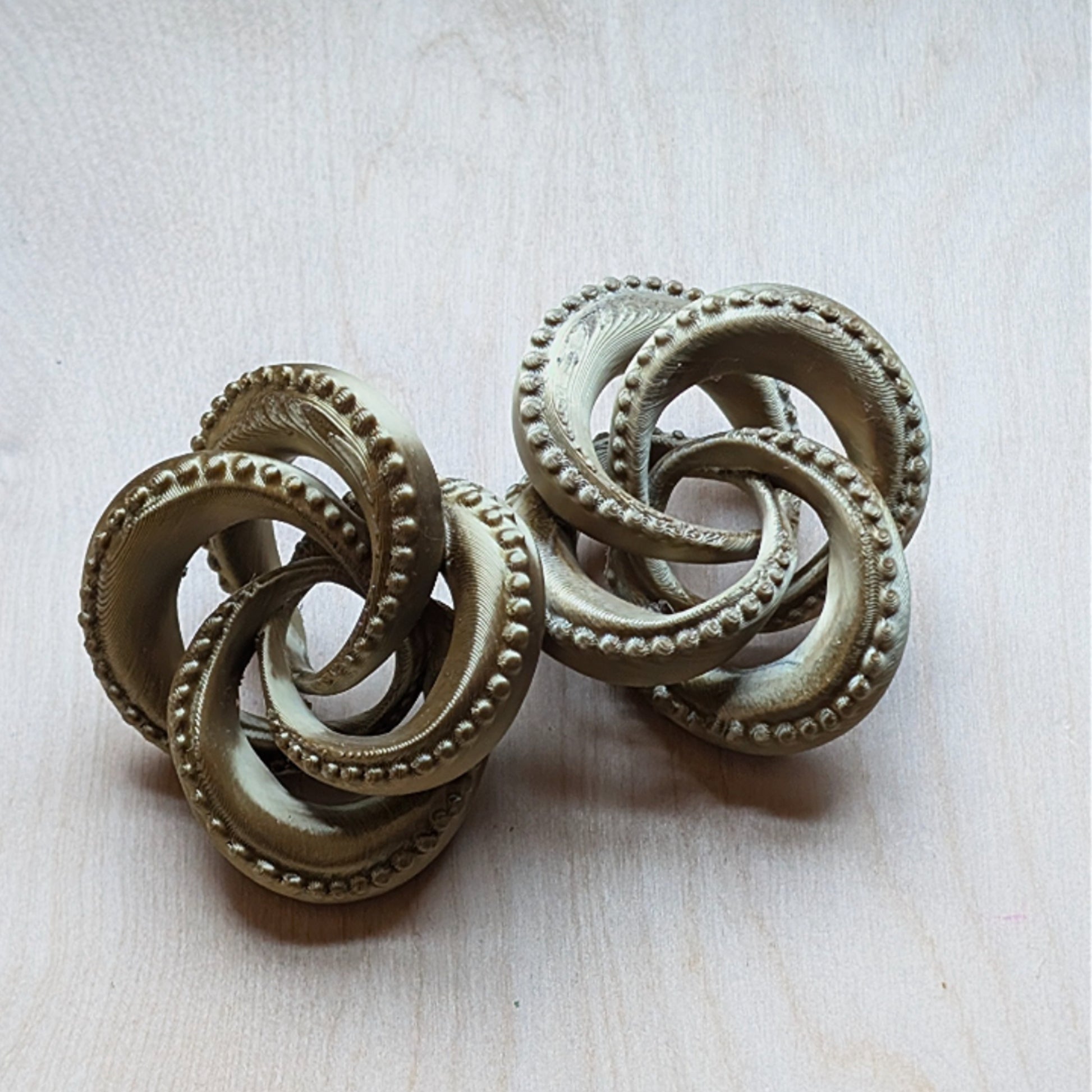 Large, 3D printed, antique gold tentacle knot earrings. 