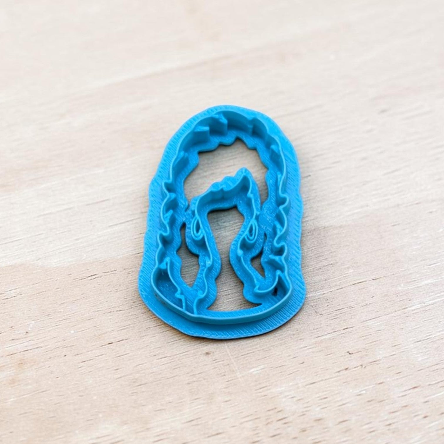 Big Hair Country Singer Bust Cookie Cutter – blue 3D printed polymer clay and fondant cutter with detailed wavy hair design on wooden background.