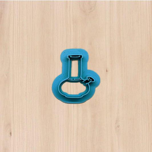 Plastic blue bong shape cookie cutter on a wooden surface