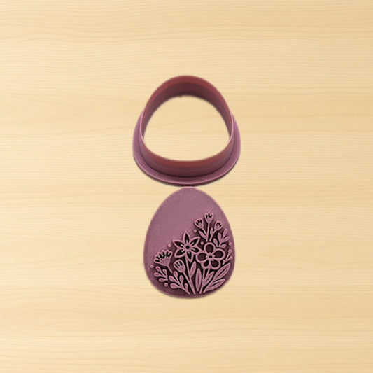 Purple cookie cutter with floral design on a beige background