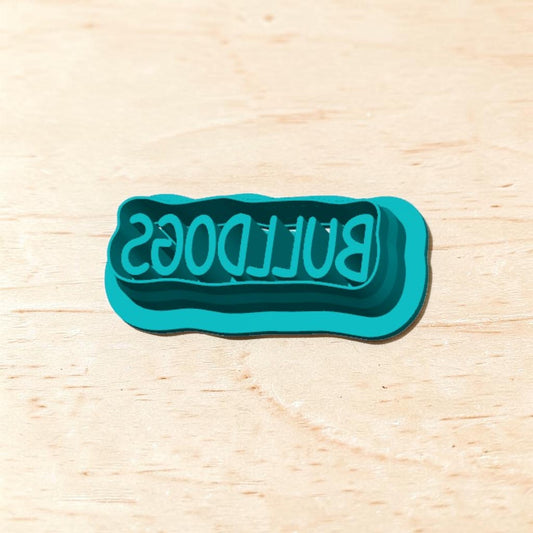Teal Bulldogs rectangle cookie cutter text design on a light wooden background, ideal for school spirit cookies, fondant, or clay crafts.