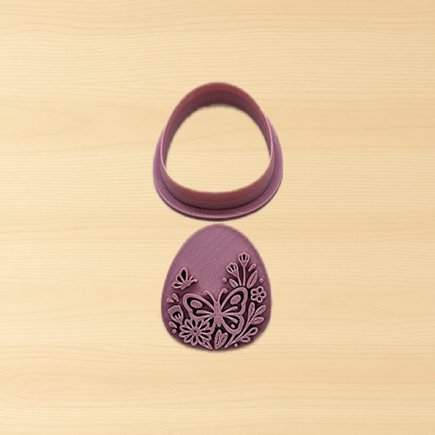 Purple plastic floral egg stamp and cutter set on a wood surface
