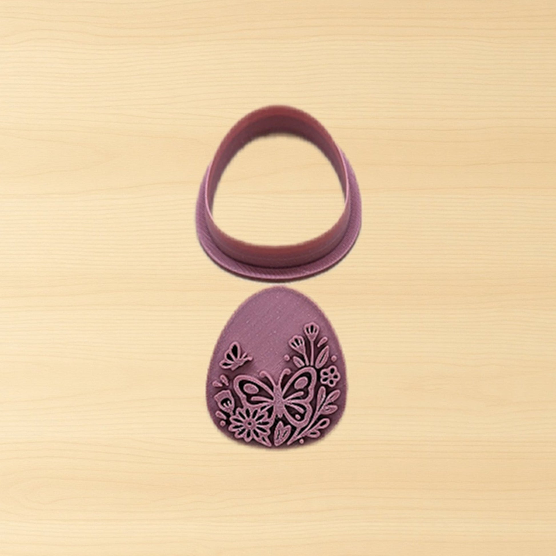 Purple plastic floral egg stamp and cutter set on a wood surface