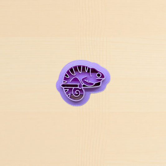 Purple lizard-shaped cookie cutter on a beige background