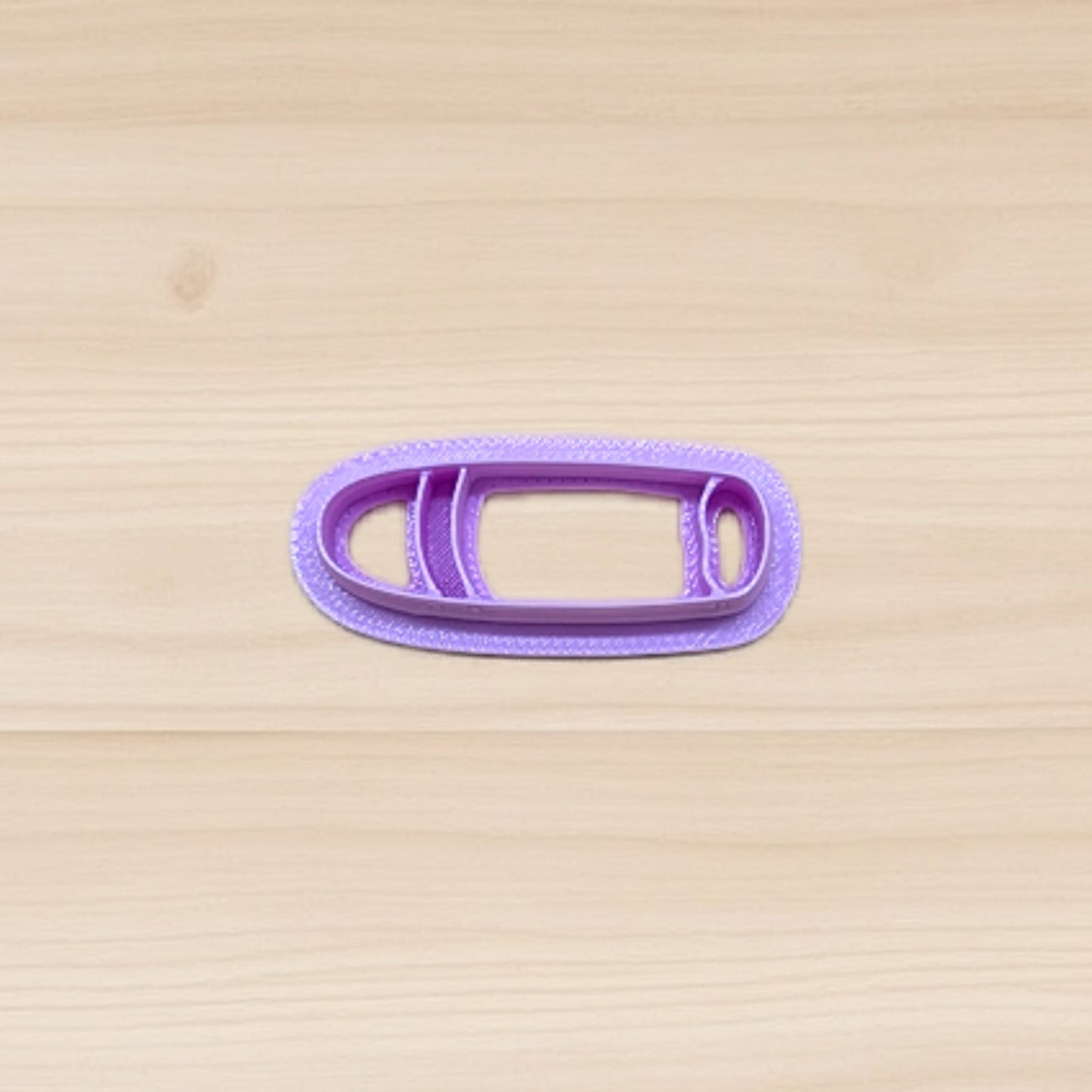 Purple cigar shape cookie cutter on a wooden surface