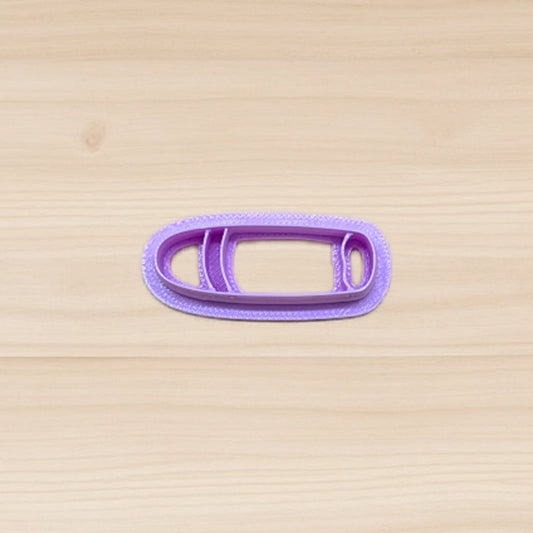 Purple cigar shape cookie cutter on a wooden surface