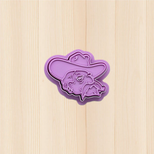 Purple Ole Miss Colonel Reb Head cookie cutter and embossing stamp on a wooden surface