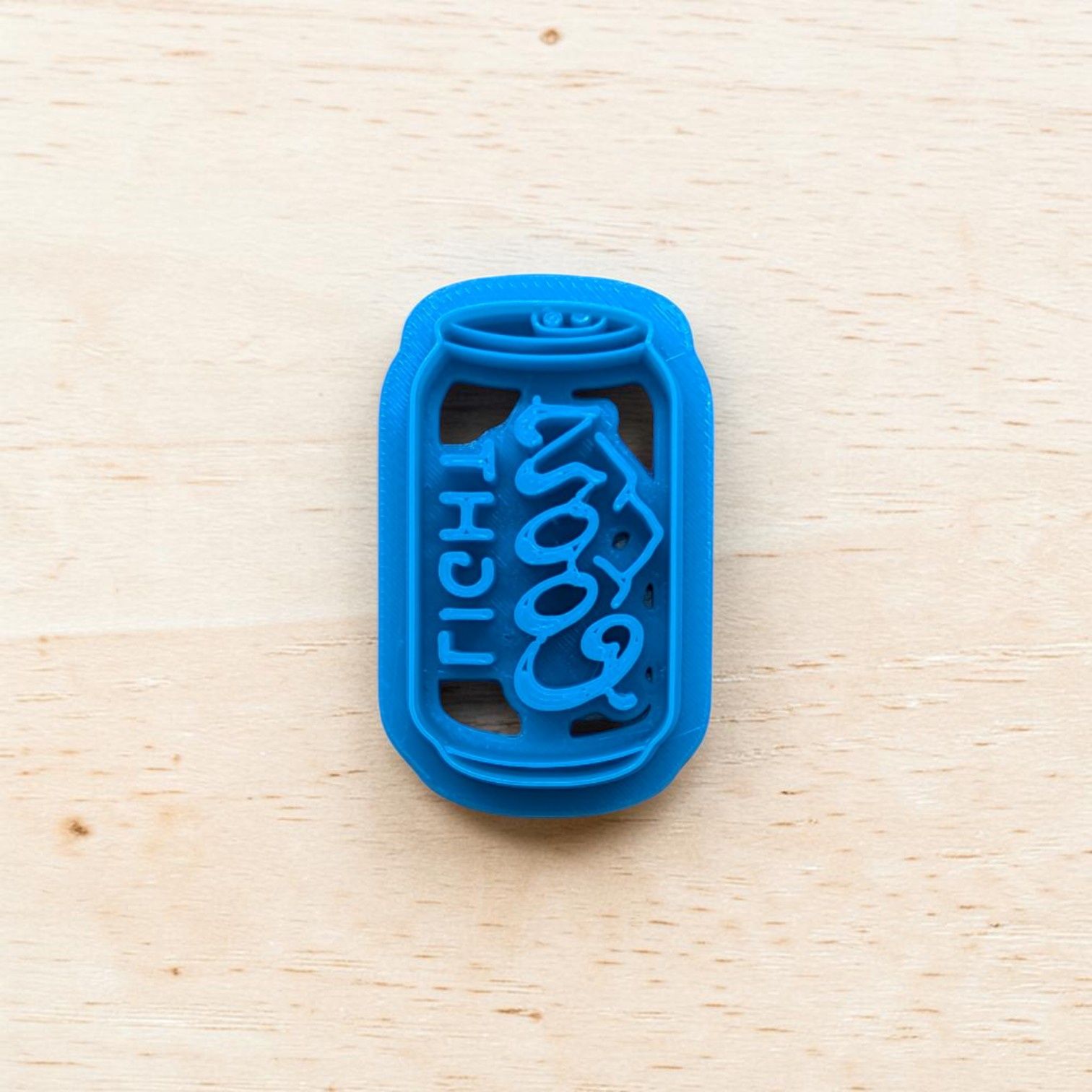 Blue Coor Light beer can cookie cutter on a light wood background