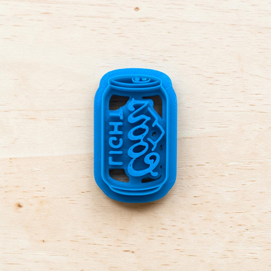 Blue Coor Light beer can cookie cutter on a light wood background