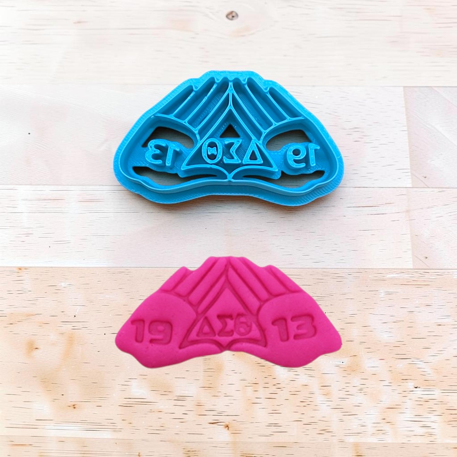 Blue delta sigma theta hands cookie cutter on a wooden surface