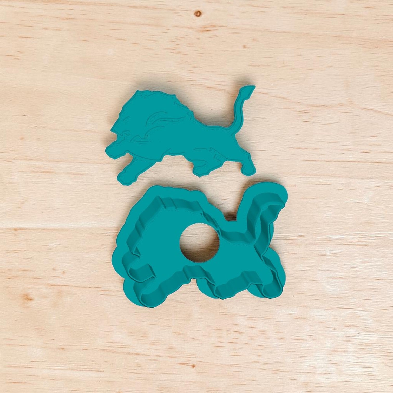 Detroit Lions cake pop mold and cutter set — teal 3D‑printed baking tool featuring lion silhouette design on wooden background.