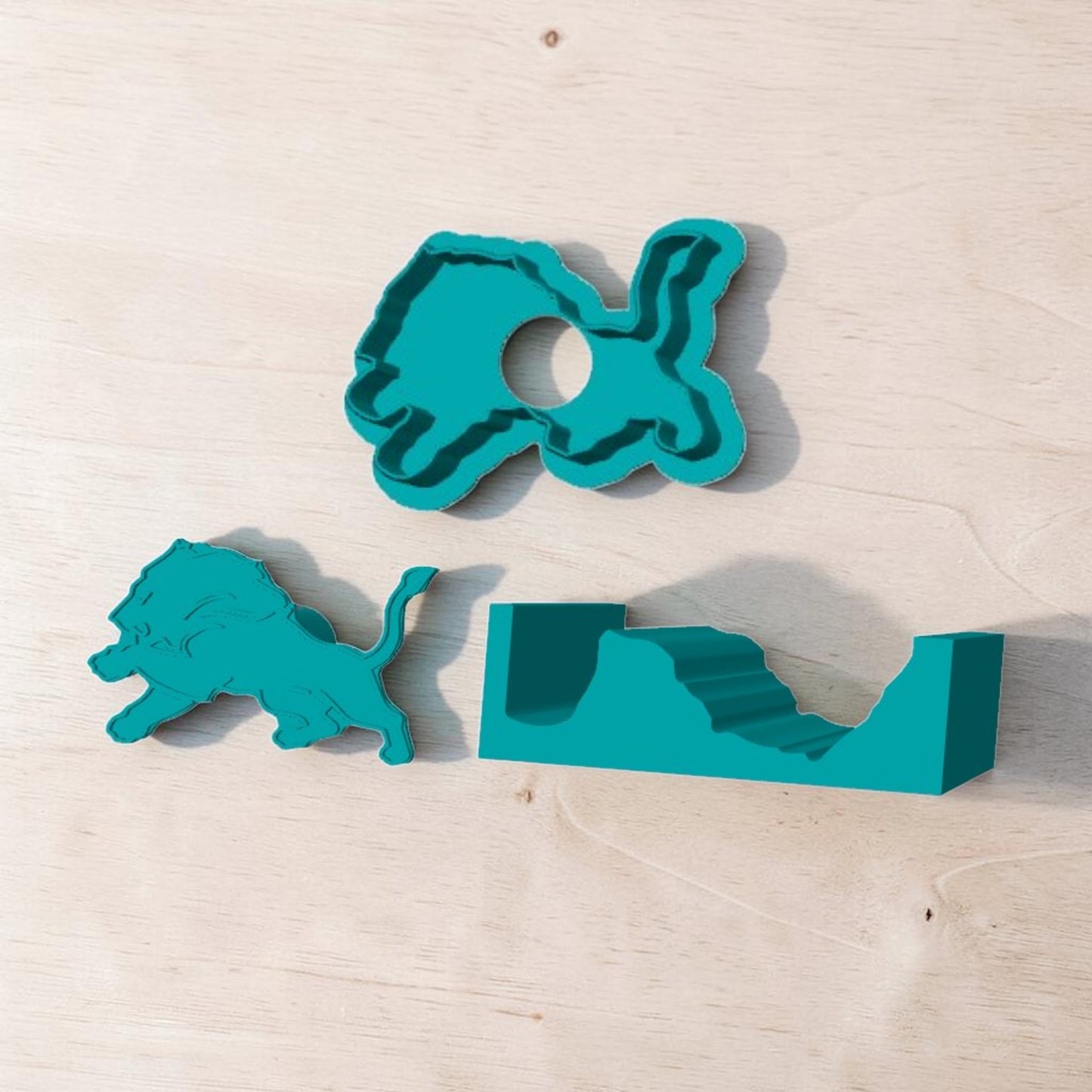 Detroit Lions 3D‑printed cake pop mold set with lion cutter, plunger, and tray — teal baking tools displayed on light wood surface.