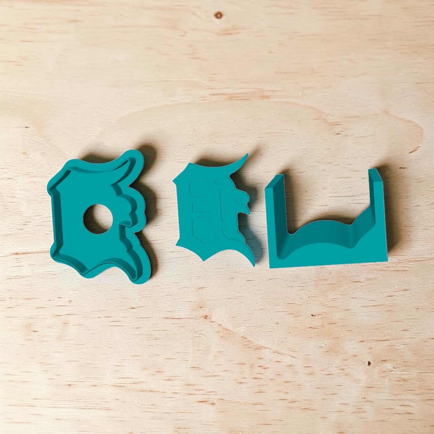 Detroit Tigers D cake pop mold set — teal 3D‑printed baking tools featuring Old English D design with plunger and tray on wooden background.