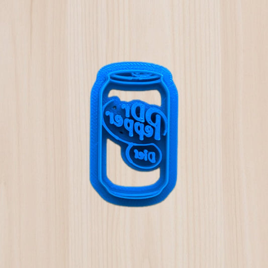 Blue Diet Dr Pepper soda can-shaped cookie cutter on a wooden surface