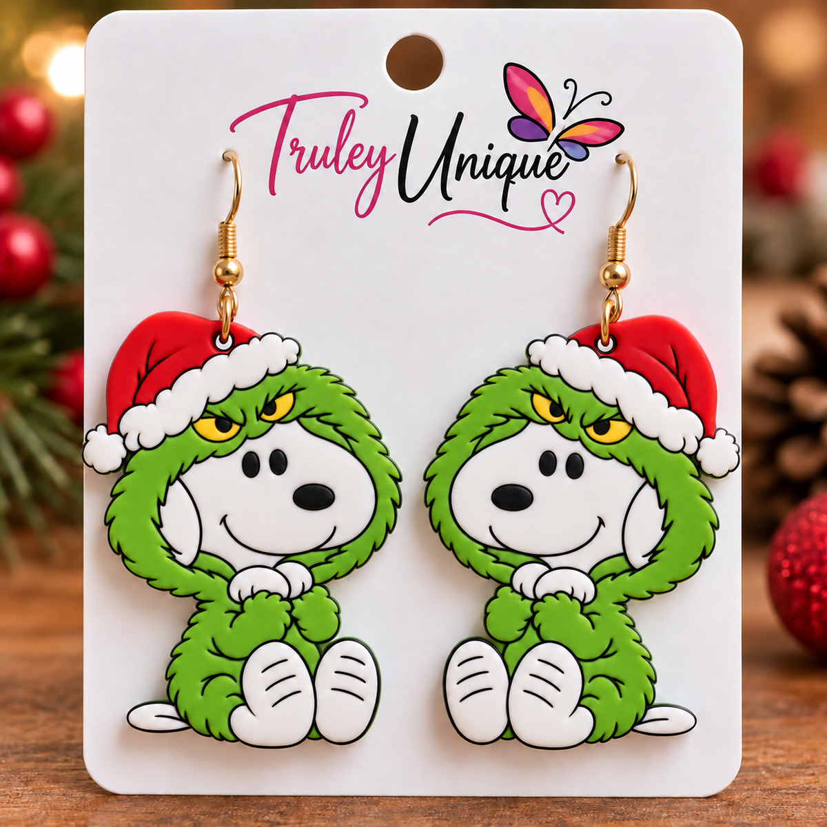 Mirrored Snoopy in Grinch Costume polymer clay Christmas earring mockup featuring green costumes, red Santa hats, yellow eyes, white dog faces, and gold hooks, displayed on a Truley Unique branded jewelry card.