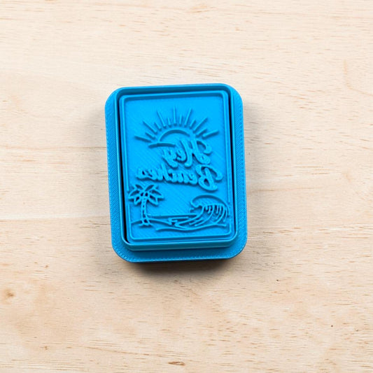Blue Hey Beach postcard stamp cutter with a beach design on a wooden surface 