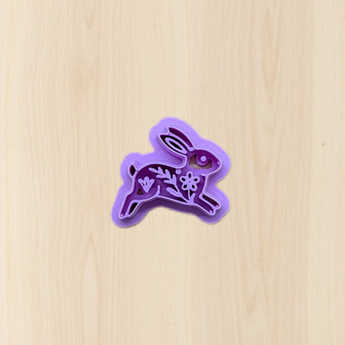 Purple bunny-shaped cookie cutter on a wooden surface