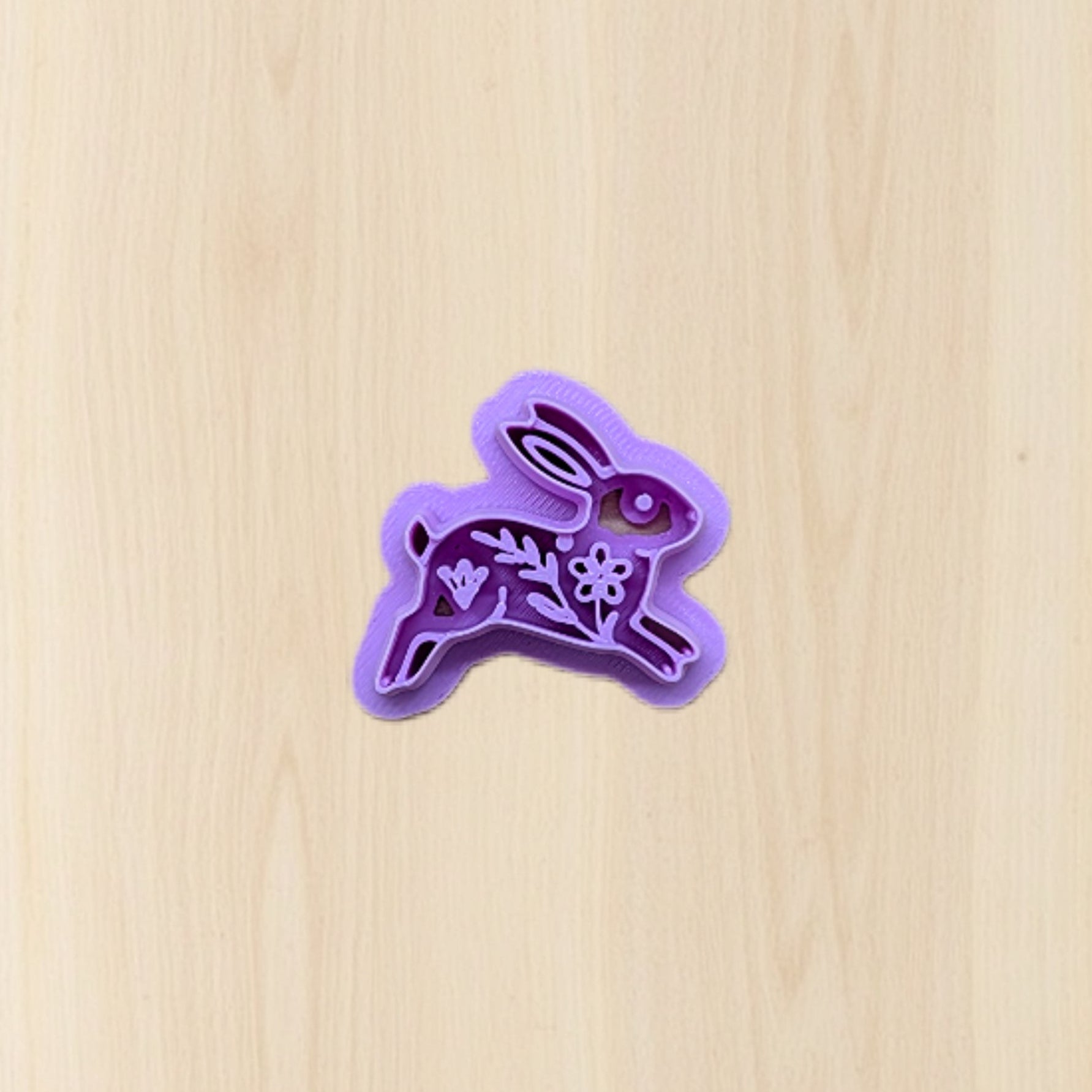 Purple bunny-shaped cookie cutter on a wooden surface