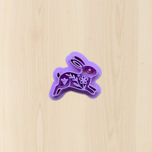 Purple bunny-shaped cookie cutter on a wooden surface