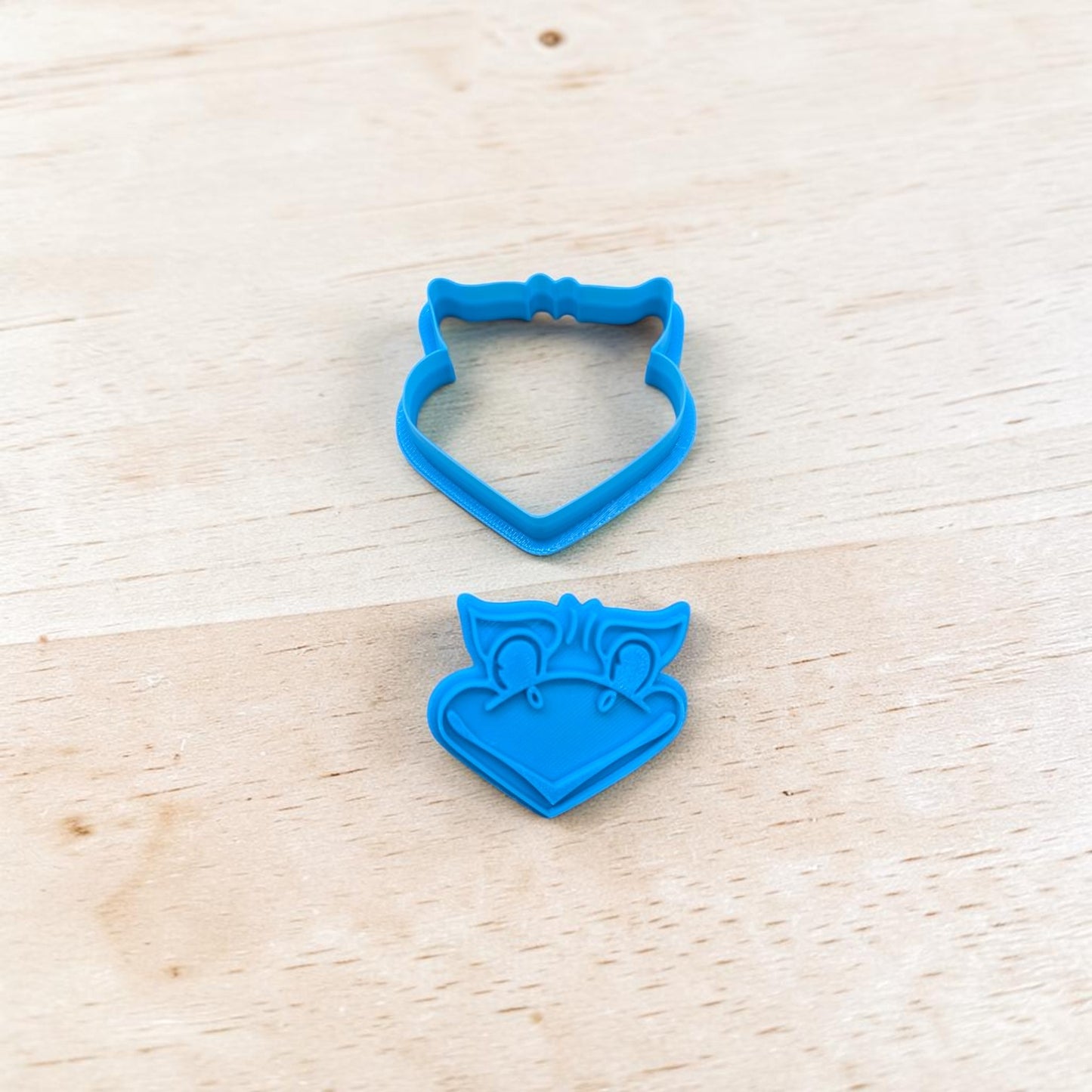 Blue Jayhawk-shaped cookie cutter on a wooden surface