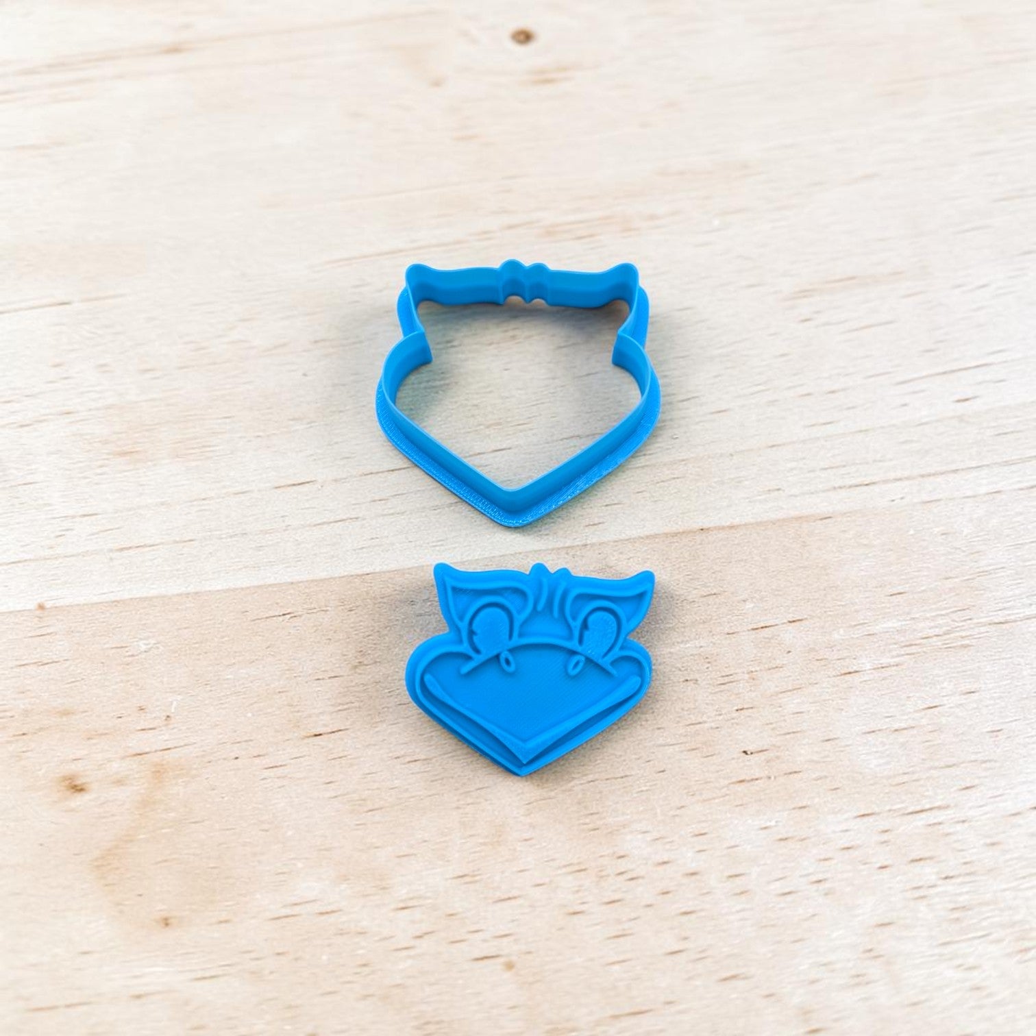 Blue Jayhawk-shaped cookie cutter on a wooden surface