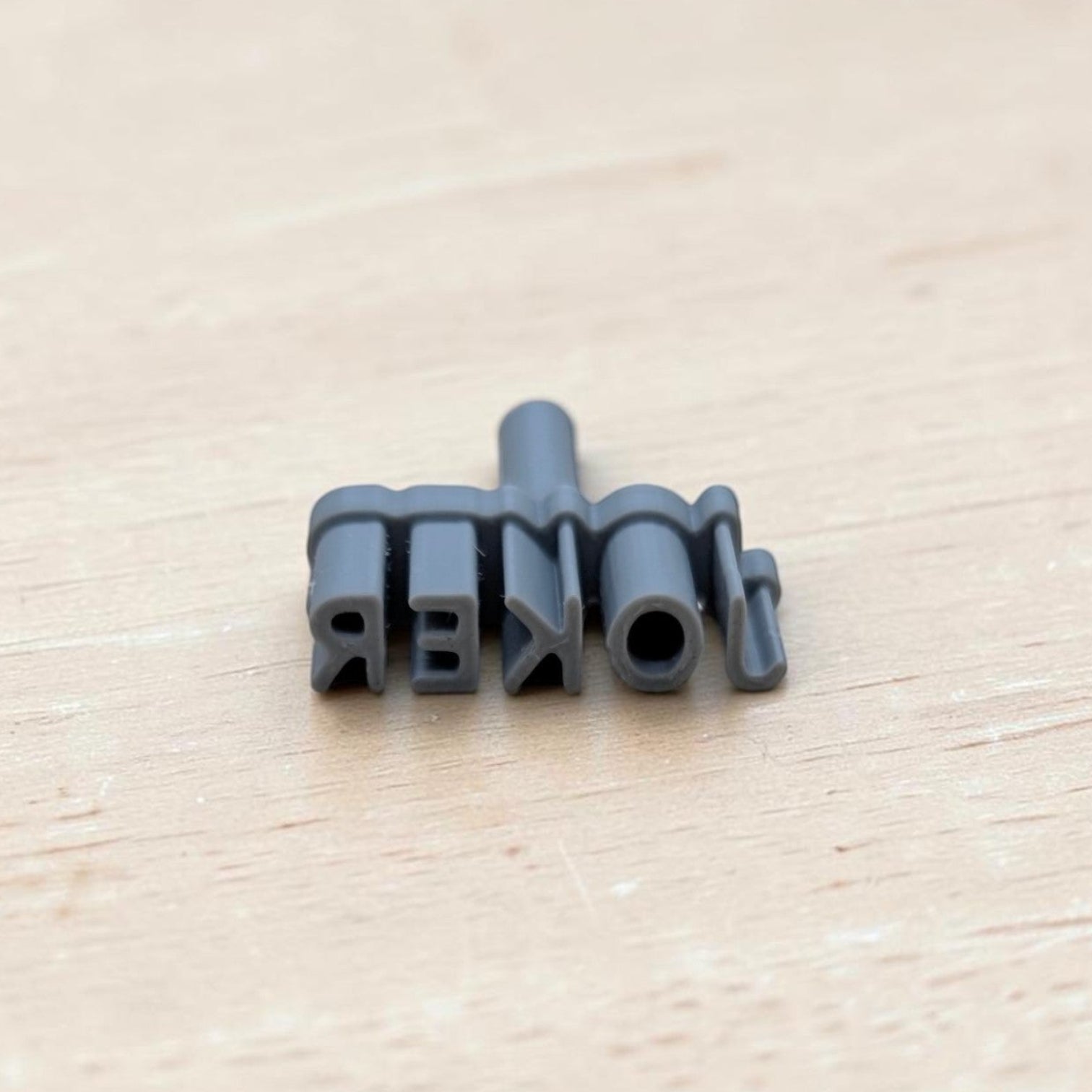 JOKER embossing stamp for cookies, fondant, polymer clay, and pottery — reversed text view showing 3D‑printed detail on light wood background.