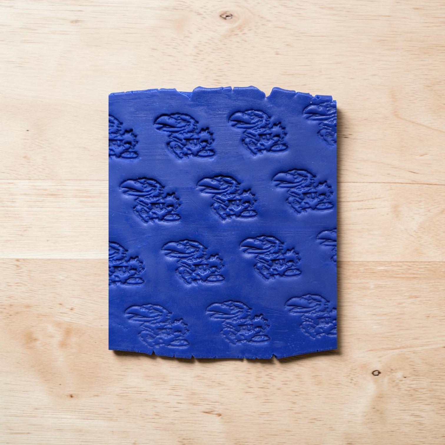 Blue textured square object on a wooden surface