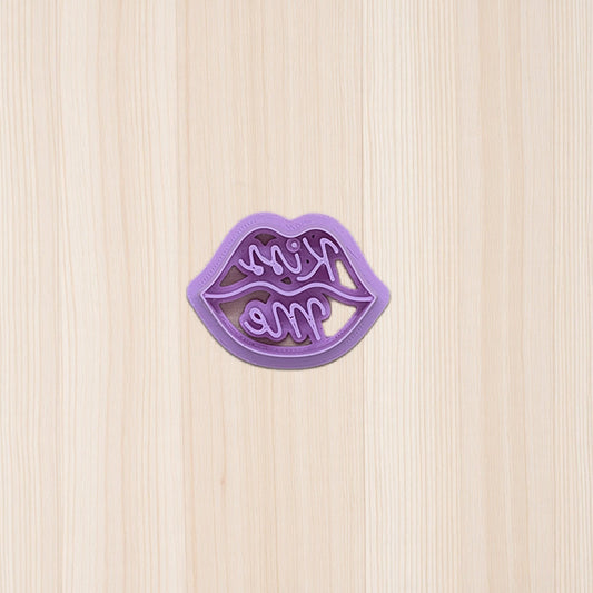 lip-shaped cookie cutter on a wooden surface