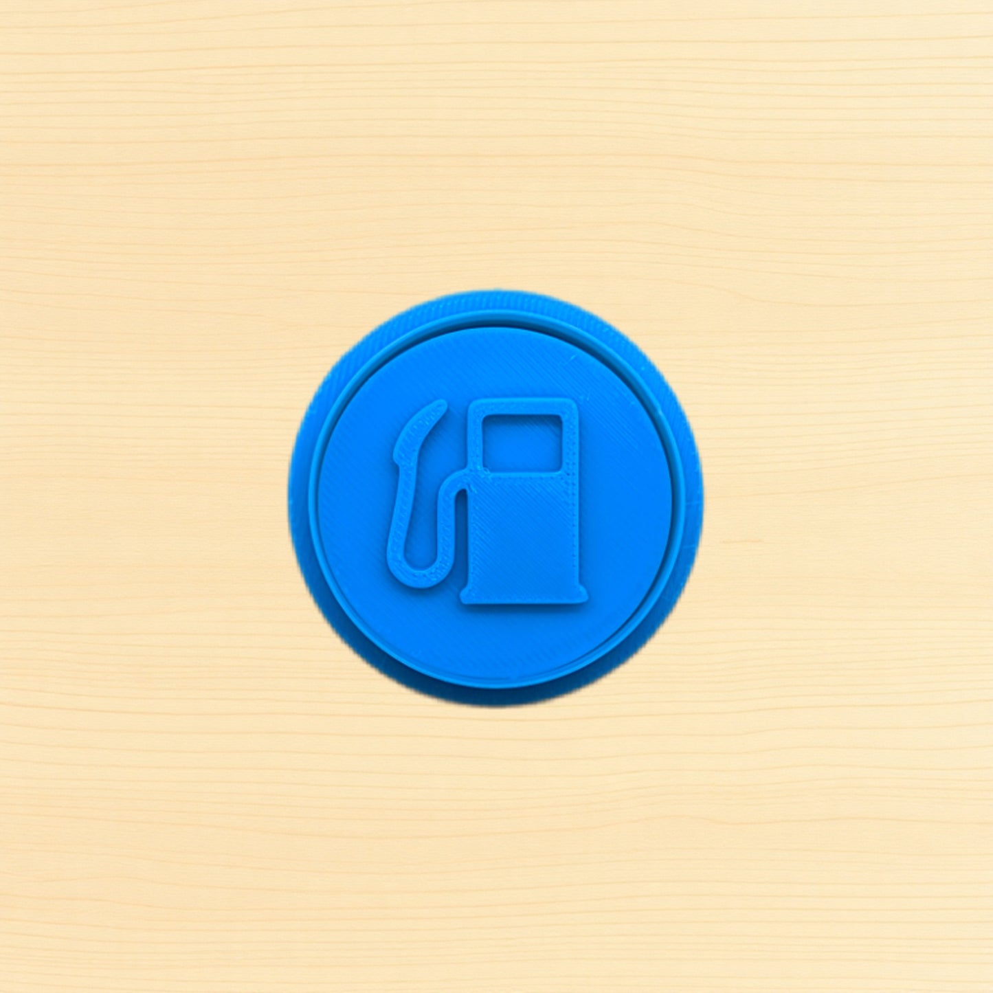 Blue fuel pump icon cookie cutter and embossing stamp on a wood background