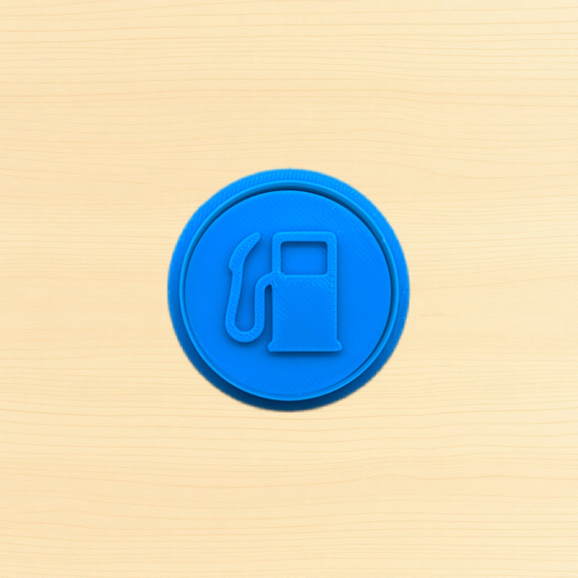 Blue fuel pump icon cookie cutter and embossing stamp on a wood background