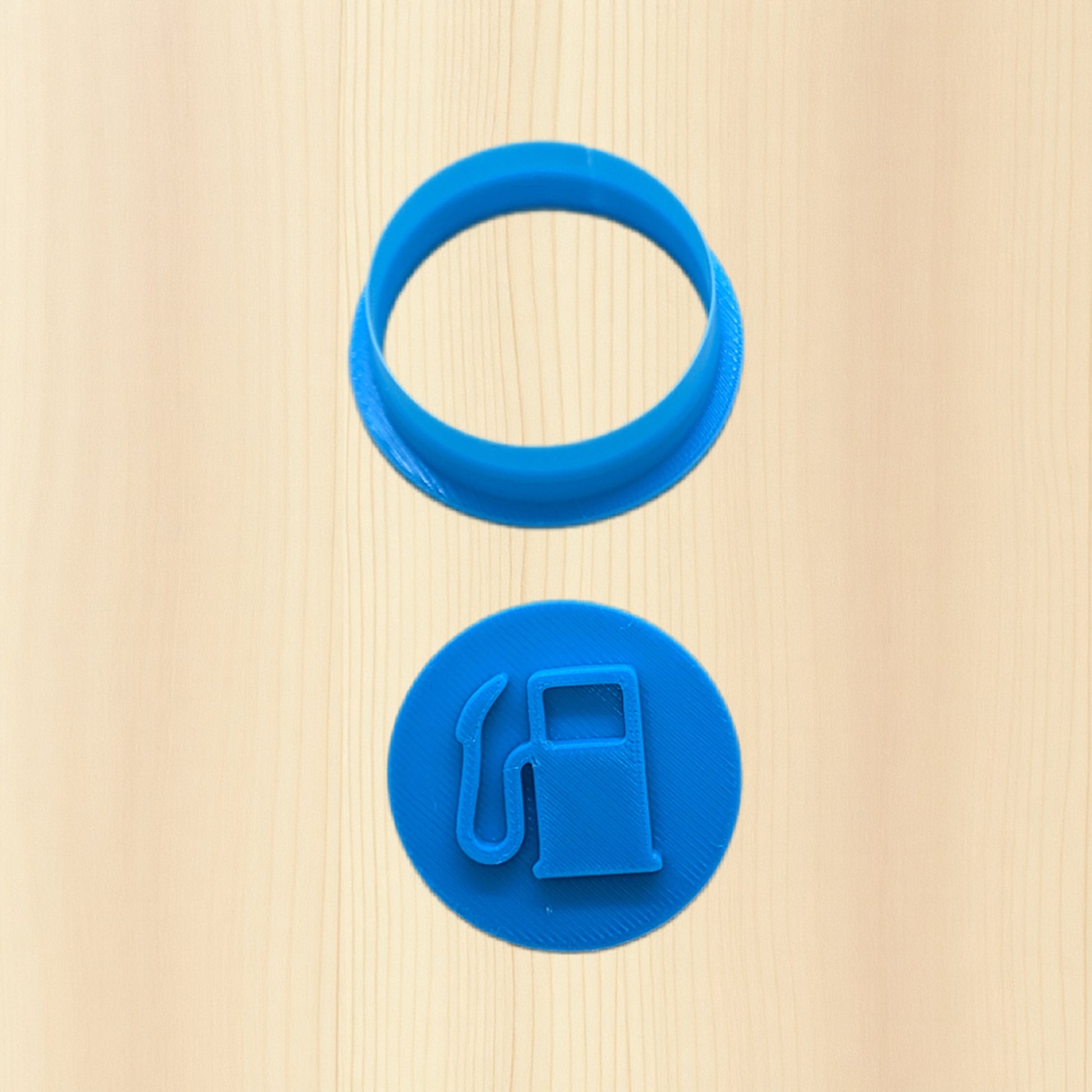 Plastic blue fuel pump cookie cutter icon on a wood background