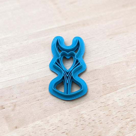 Blue plastic Maleficent shape cutter on a light wood surface