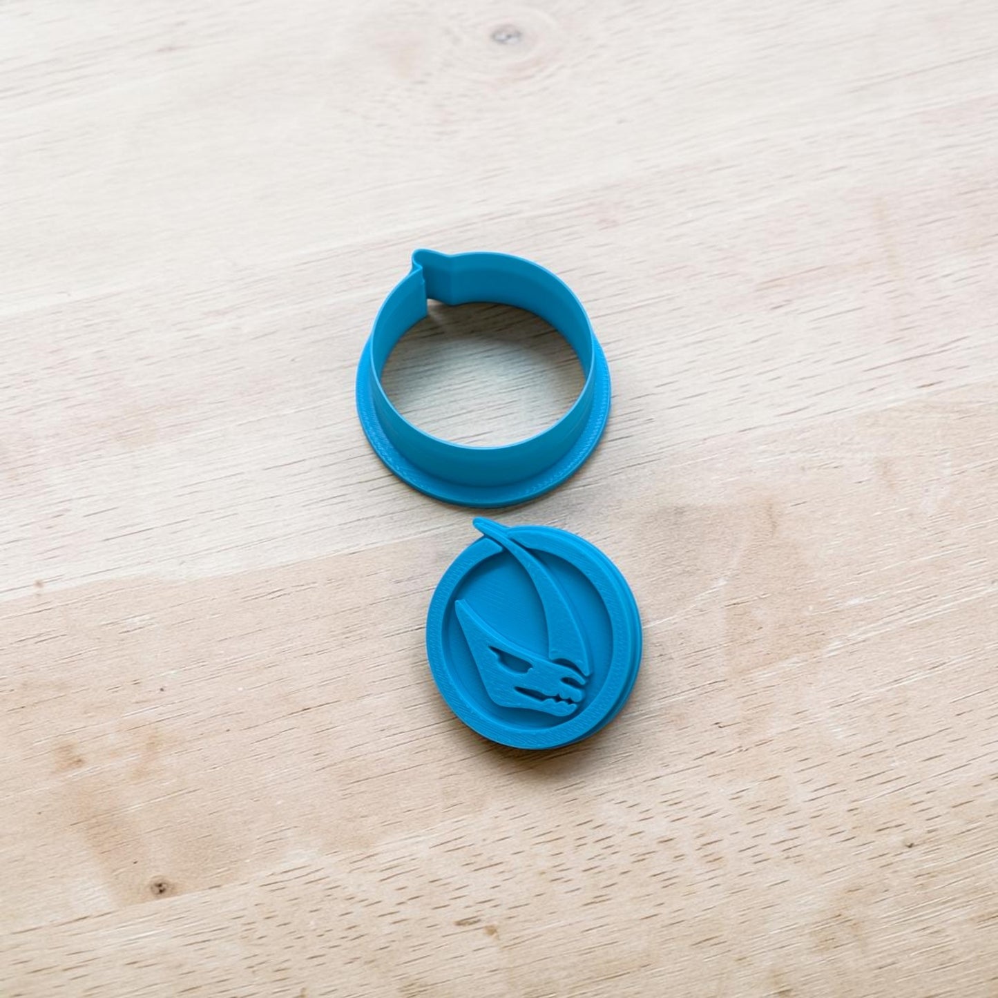 Two blue circular cookie cutters on a wooden surface