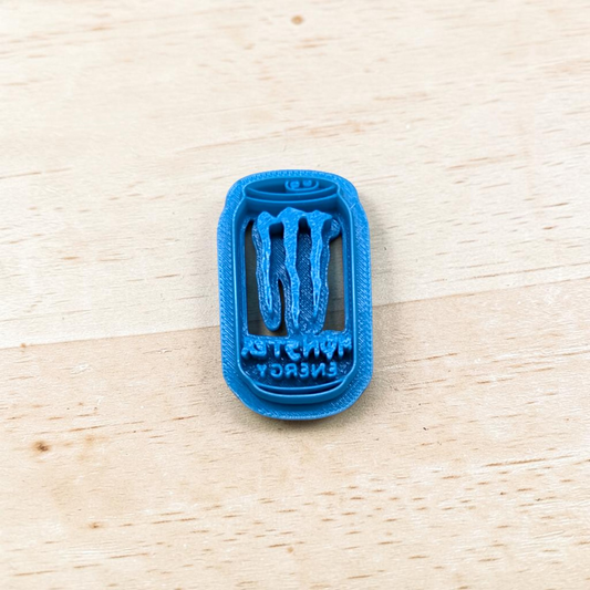 Blue 3D-printed Monster Energy Drink Can cookie cutter on a wooden surface