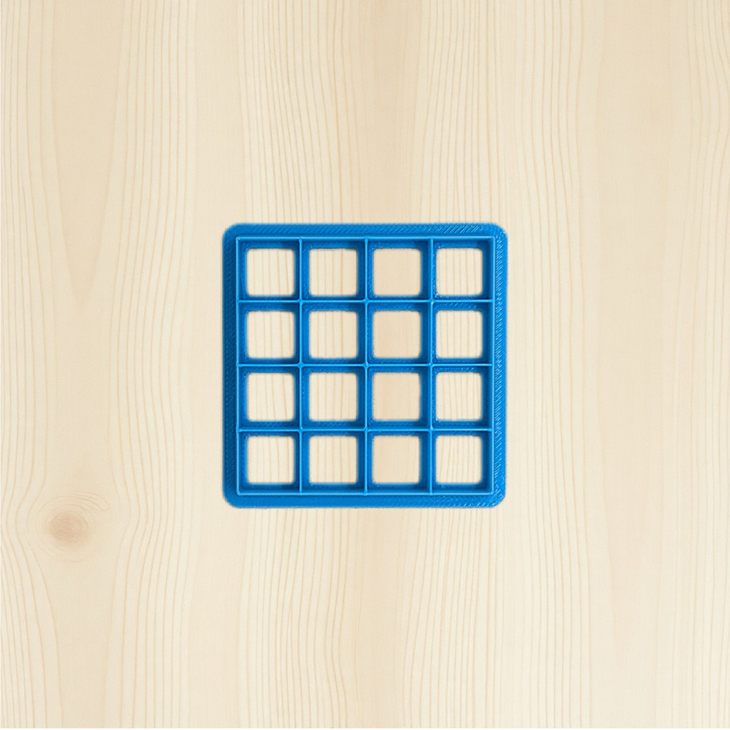 Blue grid-shaped object on a beige wooden surface