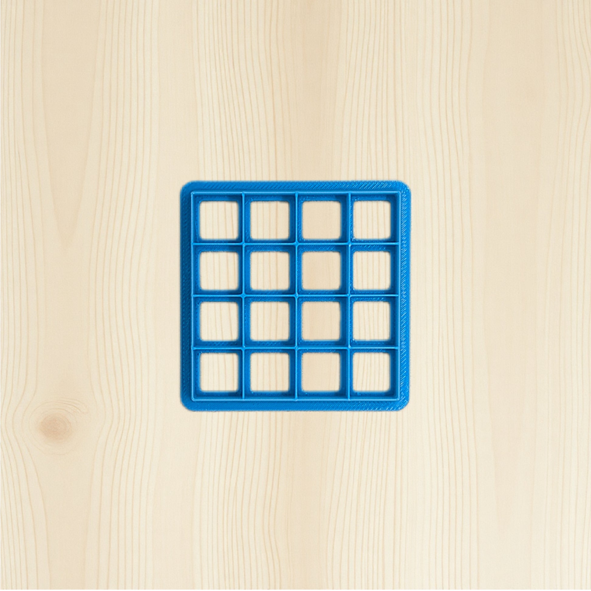 Blue grid-shaped object on a beige wooden surface