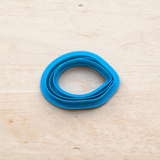 Blue mussel-shaped cookie cutter on a wooden surface