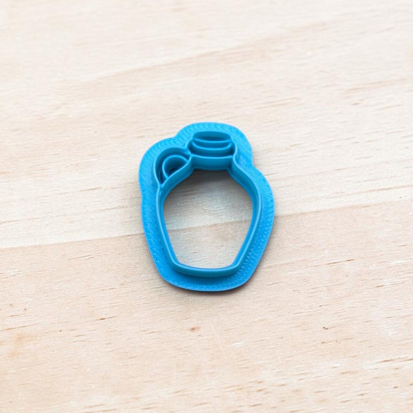 Blue 3D printed Old Fashion Jug cookie cutter on light wood background, perfect for cookies, fondant, and clay crafts.